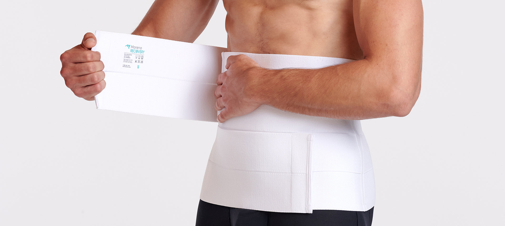 Man wearing and adjusting the closure on a white post-surgical abdominal binder.