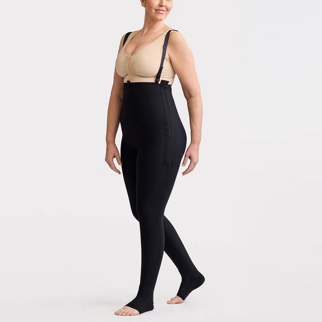 Marena Recovery style LIPSGSZ, Lipedema Post-Surgical Girdle with side zipper closures and suspenders in black, shown from the side on a female model.